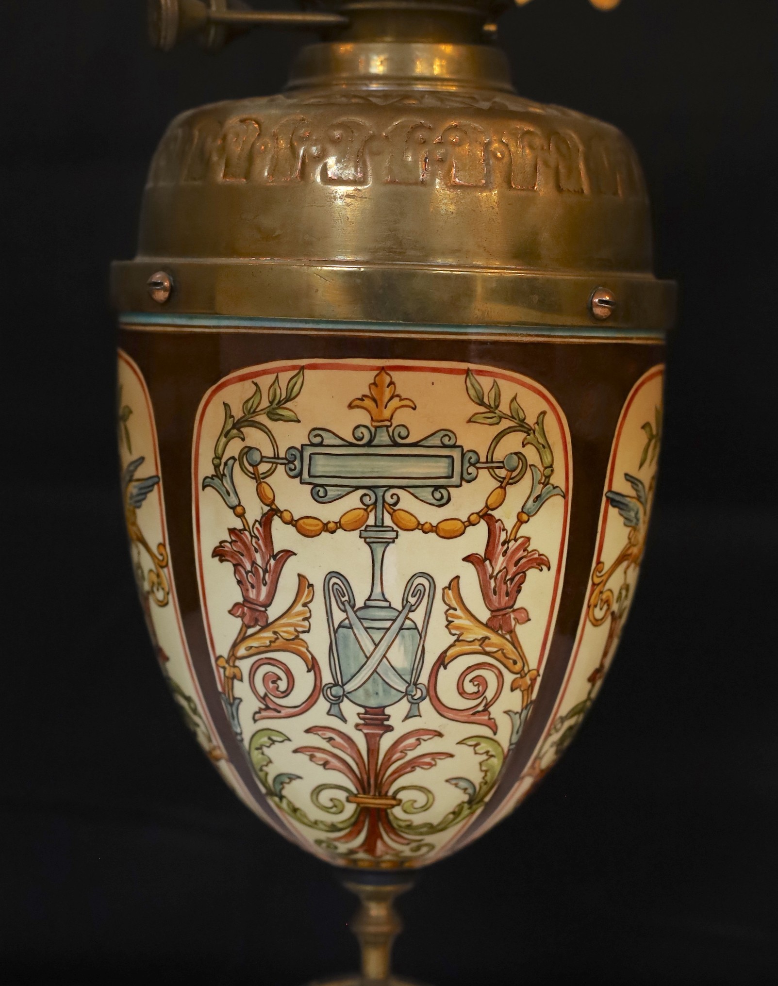A Victorian brass mounted ceramic oil lamp in the manner of Dalton with brass reservoir and frosted glass shade decorated with birds, height overall 64cm